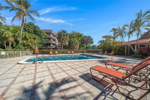 pool featuring fence and a patio area