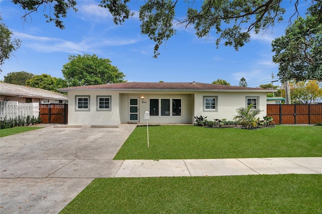 ranch-style house featuring driveway, stucco siding, a front yard, and a gate
