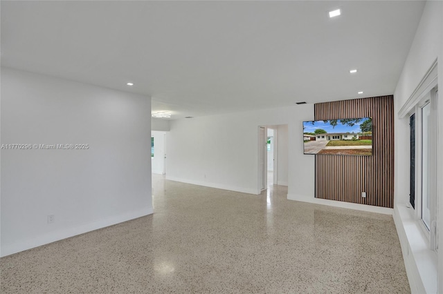 unfurnished room with baseboards, speckled floor, and recessed lighting