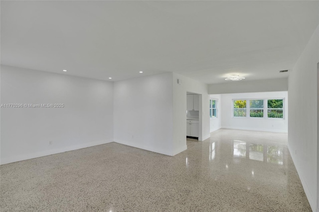 unfurnished room with recessed lighting, visible vents, and light speckled floor