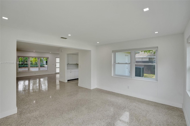 unfurnished room with recessed lighting, speckled floor, baseboards, and visible vents