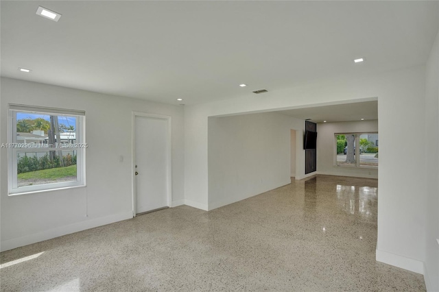 spare room with baseboards, visible vents, speckled floor, and recessed lighting