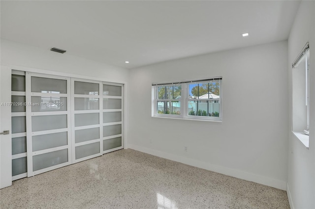unfurnished room with speckled floor, baseboards, and recessed lighting