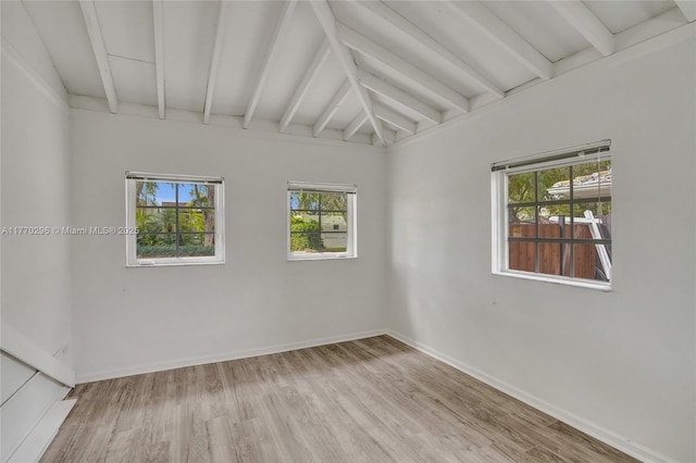 unfurnished room featuring baseboards, beamed ceiling, and wood finished floors
