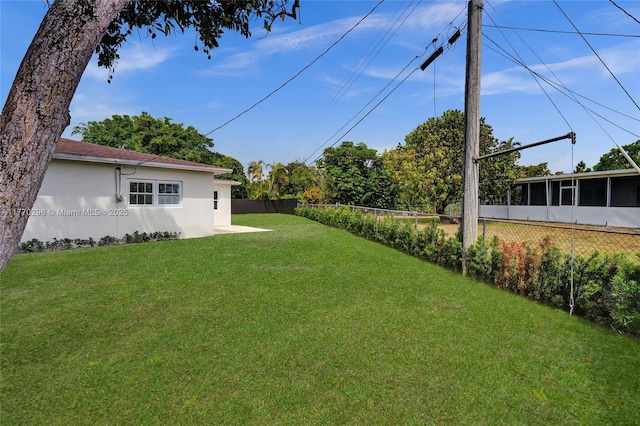 view of yard featuring a sunroom and fence