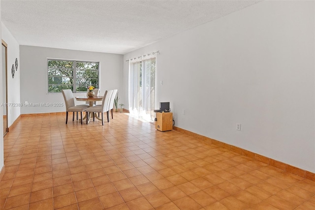 dining area with baseboards and a textured ceiling