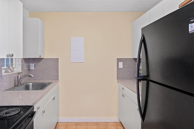 kitchen featuring light countertops, a sink, black appliances, and backsplash