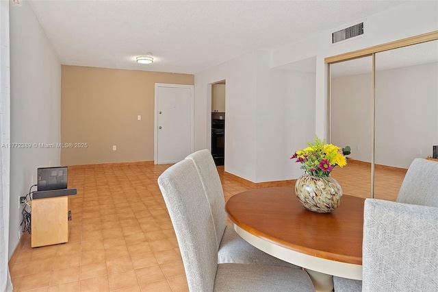 dining space with a textured ceiling and visible vents