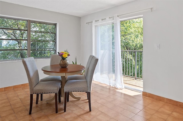 dining area featuring a textured ceiling and baseboards