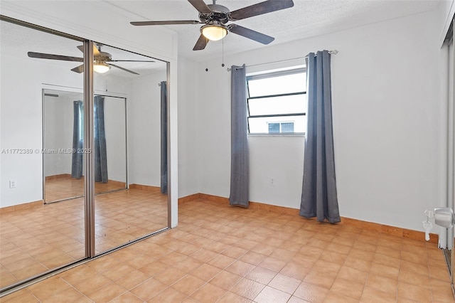 unfurnished bedroom with ceiling fan, baseboards, and a textured ceiling