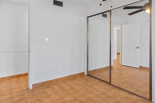 unfurnished bedroom with a closet, baseboards, a ceiling fan, and visible vents