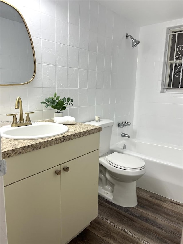 full bathroom with vanity, tile walls, toilet, and wood finished floors