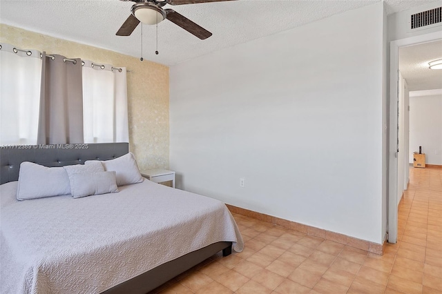 bedroom featuring visible vents, baseboards, a ceiling fan, and a textured ceiling