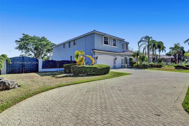 721 Ranch Rd, Weston, FL 33326 - view of front facade with stucco siding, decorative driveway, an attached garage, and a gate