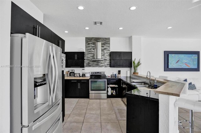 721 Ranch Rd, Weston, FL 33326 - kitchen with stainless steel appliances, dark cabinets, wall chimney range hood, a peninsula, and recessed lighting