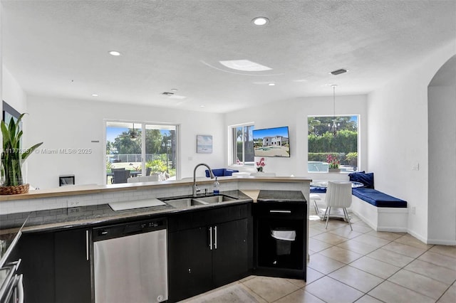 721 Ranch Rd, Weston, FL 33326 - kitchen featuring dishwasher, dark cabinets, light tile patterned floors, arched walkways, and dark countertops
