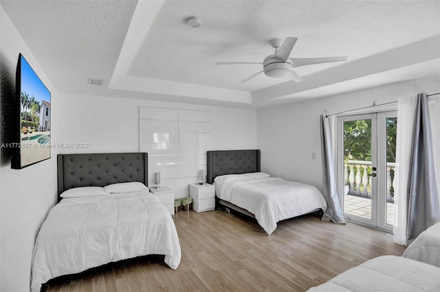 721 Ranch Rd, Weston, FL 33326 - bedroom featuring a tray ceiling, access to exterior, wood finished floors, a textured ceiling, and a ceiling fan