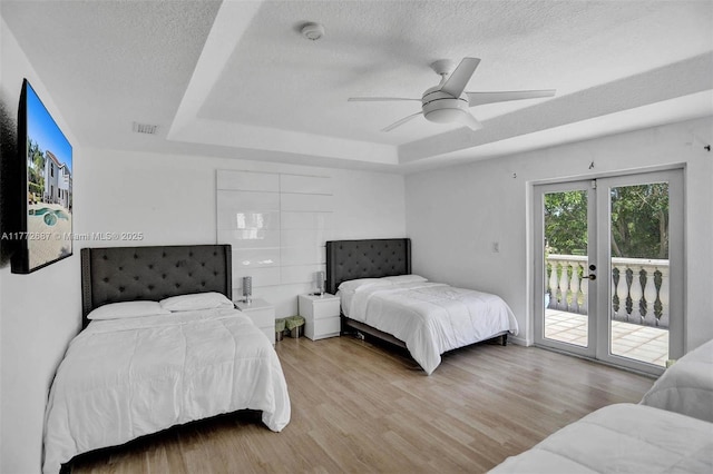721 Ranch Rd, Weston, FL 33326 - bedroom with a tray ceiling, french doors, access to outside, a textured ceiling, and wood finished floors