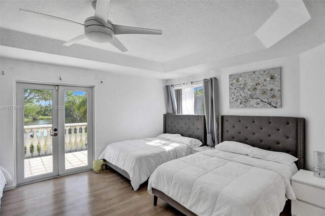 721 Ranch Rd, Weston, FL 33326 - bedroom with access to exterior, french doors, a raised ceiling, a textured ceiling, and wood finished floors