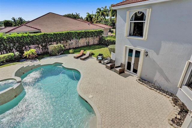 721 Ranch Rd, Weston, FL 33326 - view of swimming pool with french doors, a fenced backyard, a patio, and a pool with connected hot tub