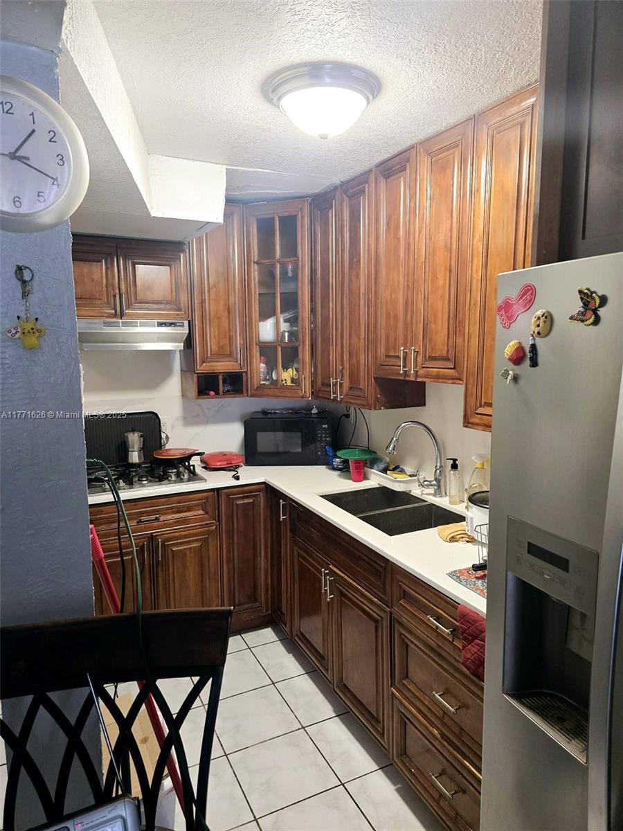 1300 W 47th Pl Unit 217B, Hialeah, FL 33012 - kitchen with stainless steel appliances, a textured ceiling, light countertops, and a sink
