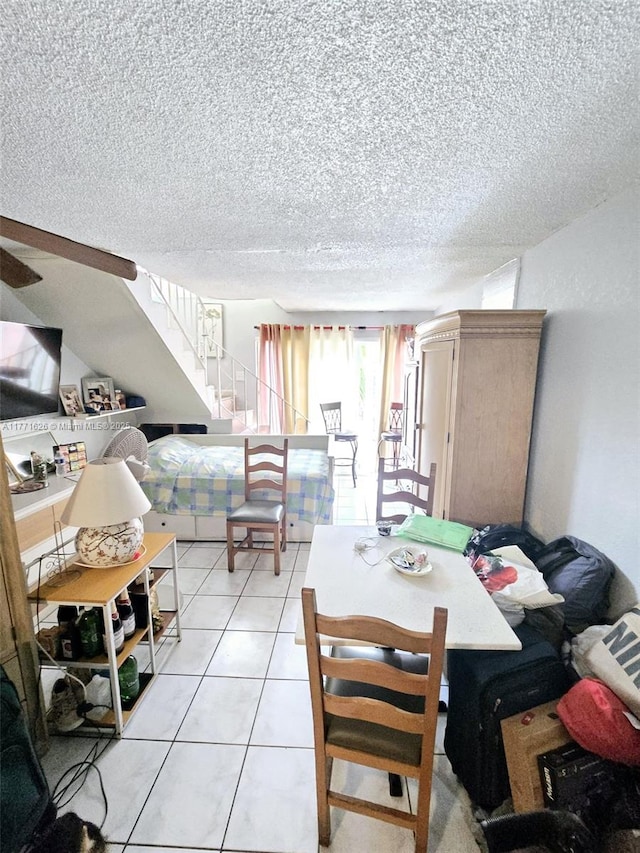 1300 W 47th Pl Unit 217B, Hialeah, FL 33012 - dining area with a textured ceiling, light tile patterned flooring, and stairs
