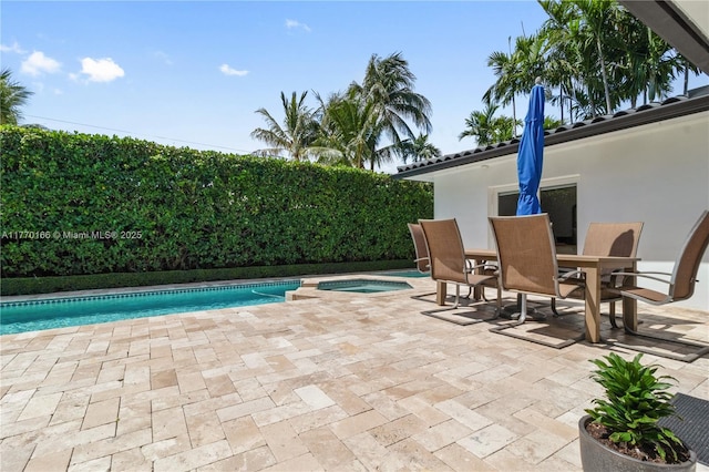 view of pool with a fenced in pool, a patio area, an in ground hot tub, and outdoor dining area