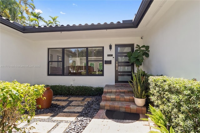 doorway to property featuring stucco siding