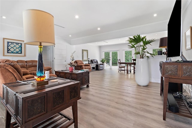 living area featuring light wood-style floors, ornamental molding, and recessed lighting