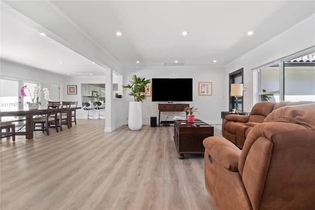 living room with crown molding, light wood-type flooring, recessed lighting, baseboards, and plenty of natural light