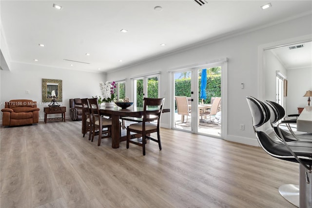dining space featuring crown molding, light wood-style flooring, visible vents, recessed lighting, and baseboards