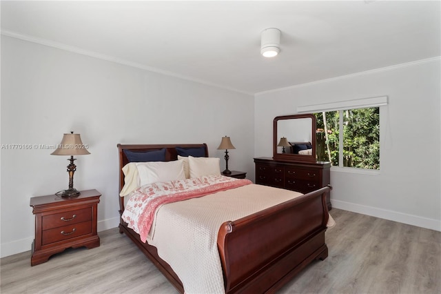 bedroom featuring ornamental molding, baseboards, and light wood finished floors
