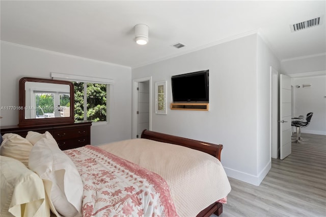 bedroom featuring crown molding, visible vents, baseboards, and light wood finished floors