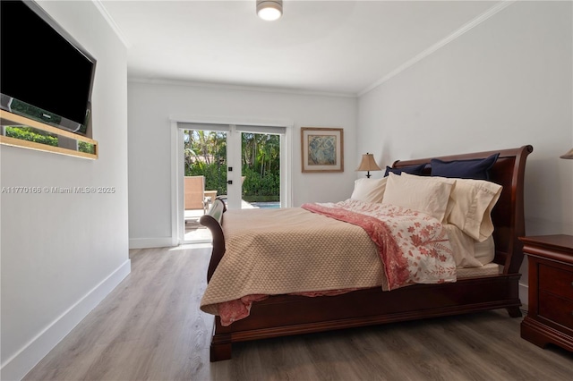 bedroom with wood finished floors, baseboards, ornamental molding, and access to exterior