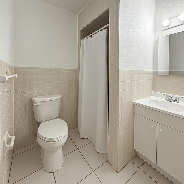 6133 SW 62nd Ter, South Miami, FL 33143 - bathroom featuring tile walls, toilet, wainscoting, tile patterned flooring, and vanity