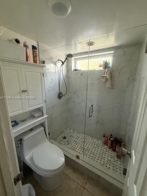 full bath with a marble finish shower, toilet, and tile patterned flooring