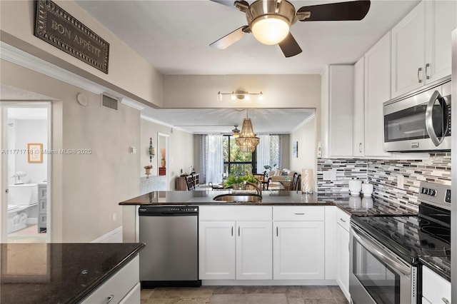 4800 Bayview Dr Unit 402, Fort Lauderdale, FL 33308 - kitchen featuring a sink, a peninsula, stainless steel appliances, visible vents, and white cabinets