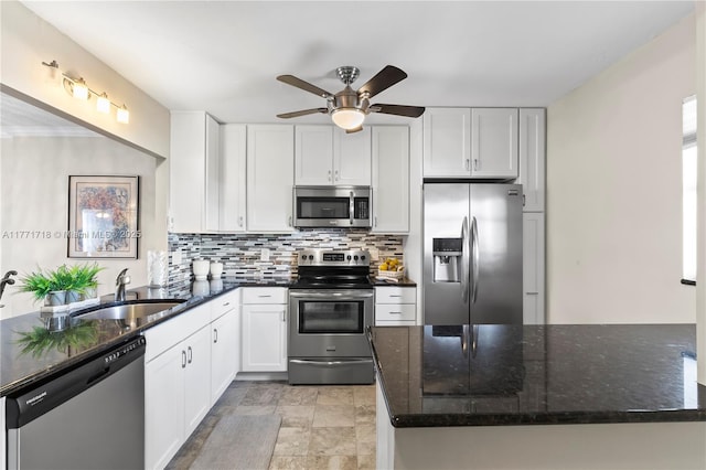 4800 Bayview Dr Unit 402, Fort Lauderdale, FL 33308 - kitchen with decorative backsplash, a sink, white cabinets, a ceiling fan, and appliances with stainless steel finishes