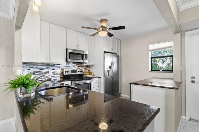 4800 Bayview Dr Unit 402, Fort Lauderdale, FL 33308 - kitchen featuring backsplash, a sink, white cabinets, a ceiling fan, and appliances with stainless steel finishes