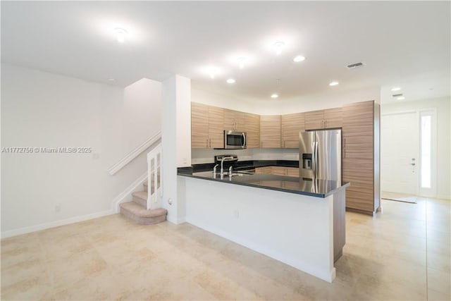 2664 SW 81st Ter Unit 2666, Miramar, FL 33025 - kitchen with appliances with stainless steel finishes, dark countertops, recessed lighting, a peninsula, and brown cabinetry