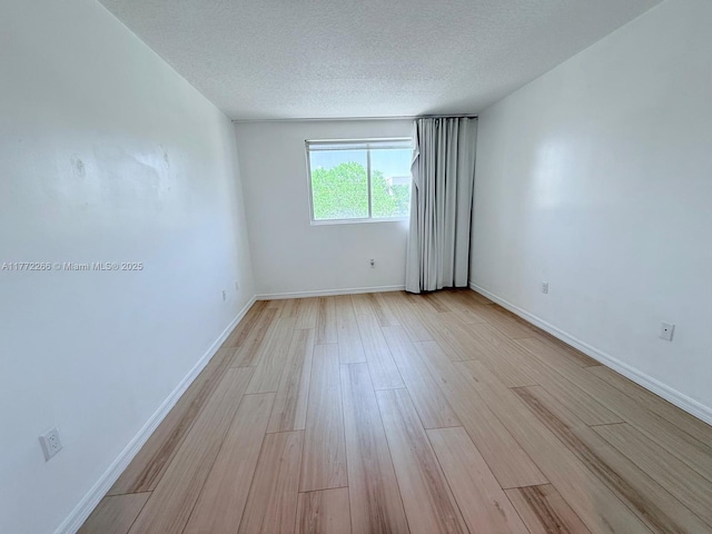 201 Golden Isles Dr Unit 311, Hallandale Beach, FL 33009 - empty room with light wood-style flooring and a textured ceiling