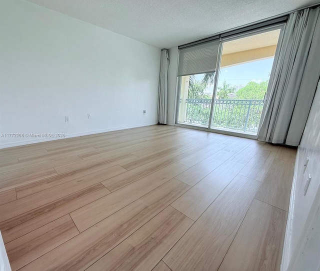 201 Golden Isles Dr Unit 311, Hallandale Beach, FL 33009 - empty room with floor to ceiling windows and light wood finished floors