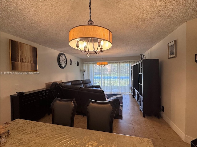 dining area featuring a textured ceiling, an inviting chandelier, baseboards, and tile patterned floors