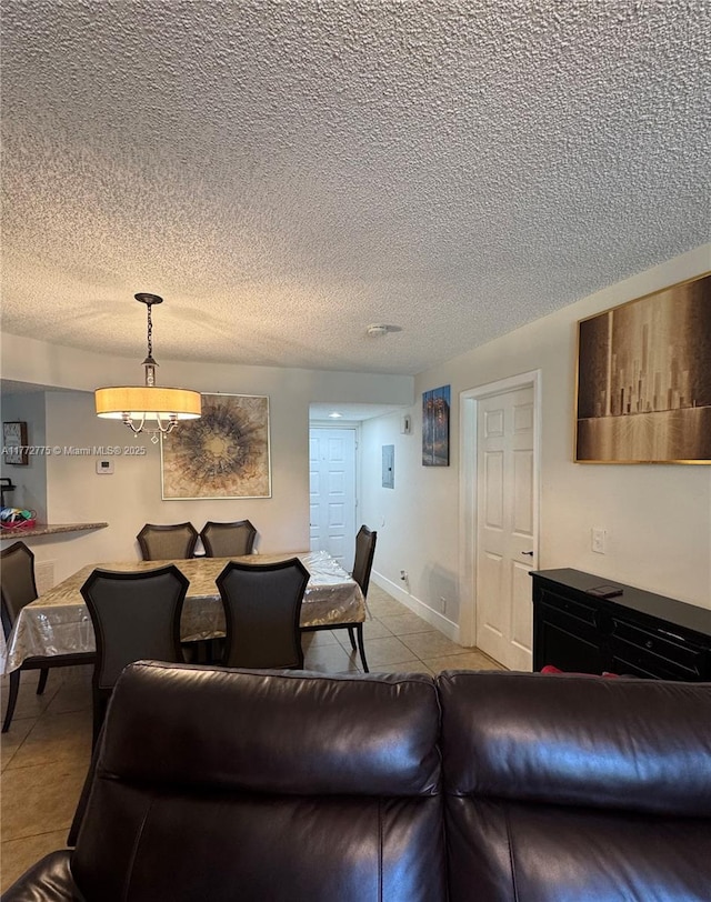 tiled living room featuring a chandelier and a textured ceiling