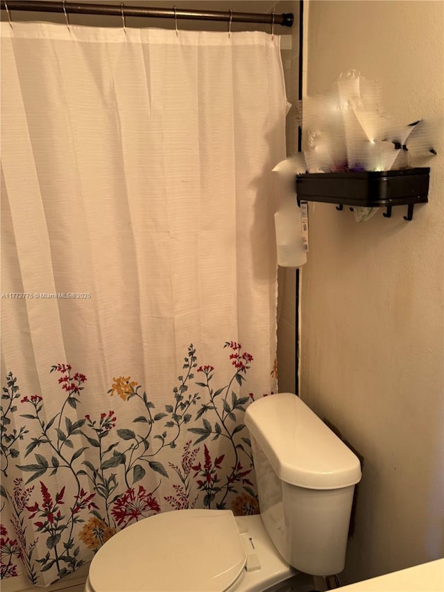 full bath featuring a shower with curtain and toilet