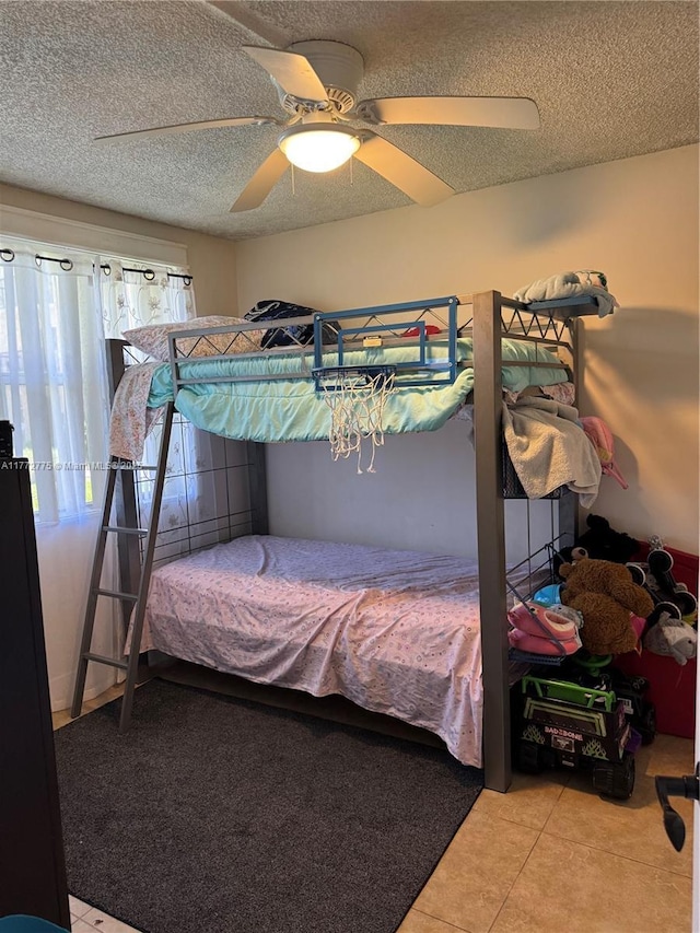 bedroom with tile patterned flooring, a textured ceiling, and ceiling fan