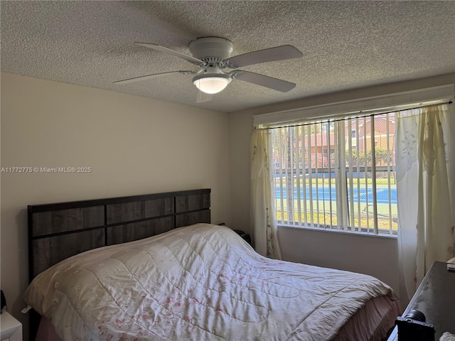 bedroom featuring ceiling fan and a textured ceiling