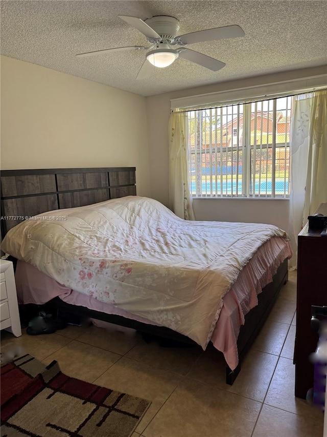 bedroom featuring tile patterned floors, a textured ceiling, and ceiling fan