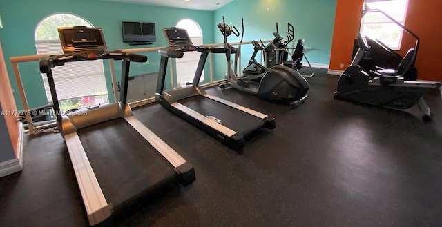 workout area featuring baseboards and a healthy amount of sunlight