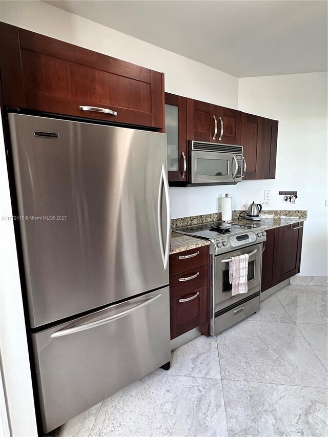 19900 E Country Club Dr Unit 1012, Aventura, FL 33180 - kitchen featuring glass insert cabinets, light stone countertops, appliances with stainless steel finishes, and dark brown cabinets